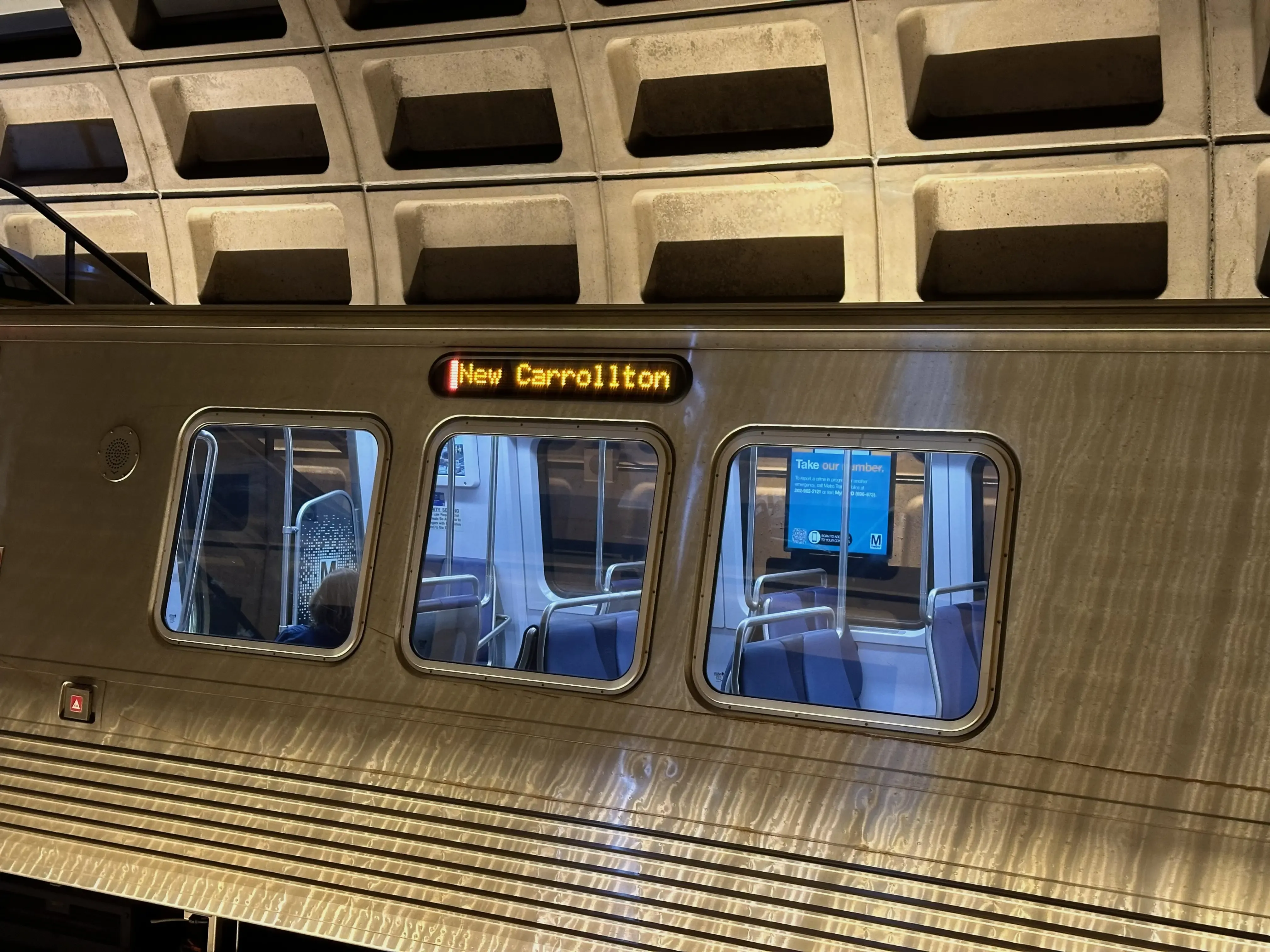 An Orange Line 7000-series train bound for New Carrollton has stopped at Farragut West.